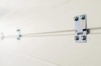 Widok na bramę z zamontowanymi metalowymi zawiasami